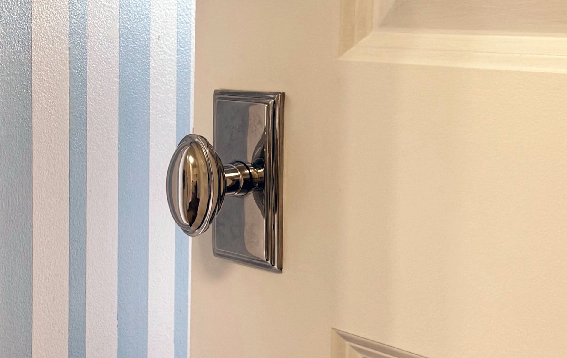 reunion interiors polished nickel door hardware grandeur carre eden prairie doorknob close up blue white striped painted wall